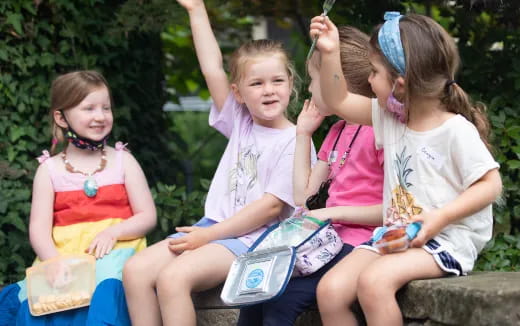 a group of girls sitting on a bench