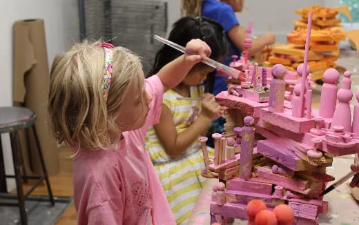 a couple of girls cutting a cake