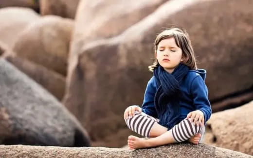 a child sitting on a rock