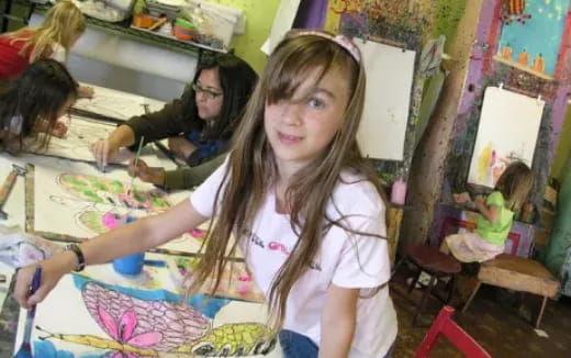 a girl painting in a classroom