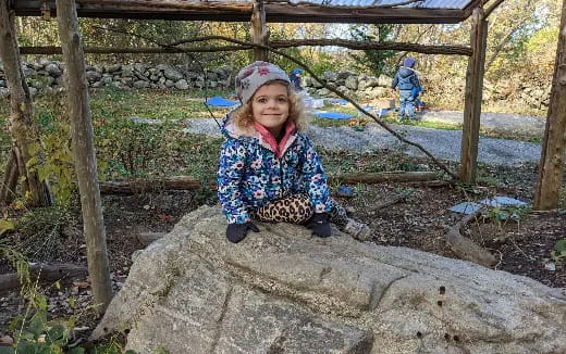 a girl sitting on a rock
