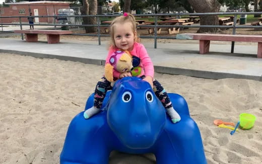 a girl riding a toy horse