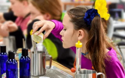 a young girl blowing out a candle