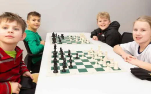 a group of children sitting at a table playing a board game