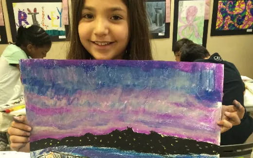 a girl holding a purple cake