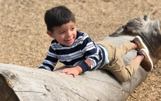 a boy lying on a log