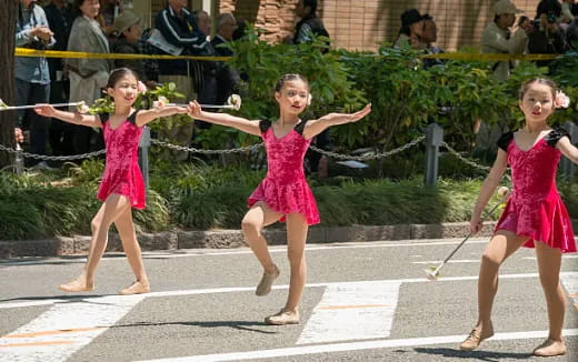a group of girls in dresses holding swords