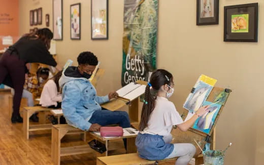 a group of people sitting at desks in a classroom