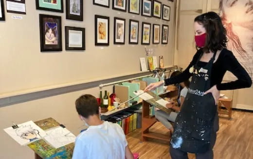a woman and a boy in a room with pictures on the wall