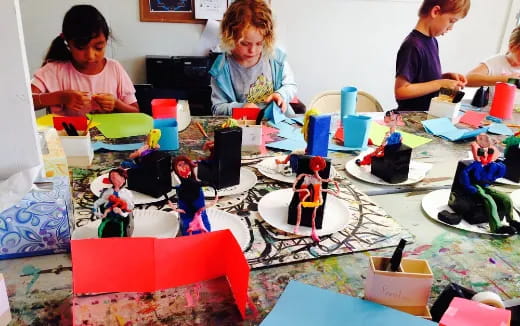 a group of people sitting around a table with a cake