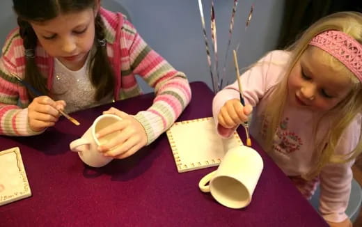 a couple of young girls eating at a table