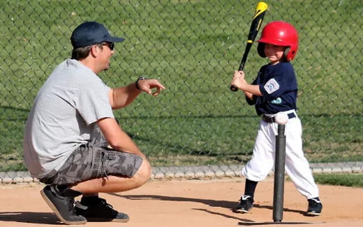 a person and a boy playing baseball