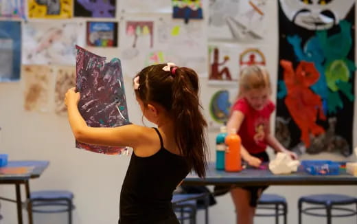 a girl drawing on a white board