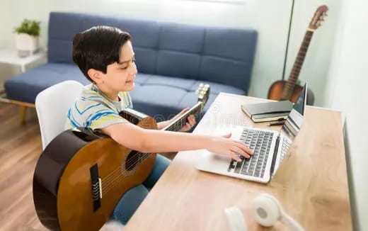 a person playing a guitar and a laptop