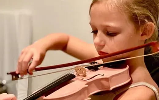 a young girl playing a violin