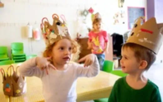 a couple of children wearing paper crowns