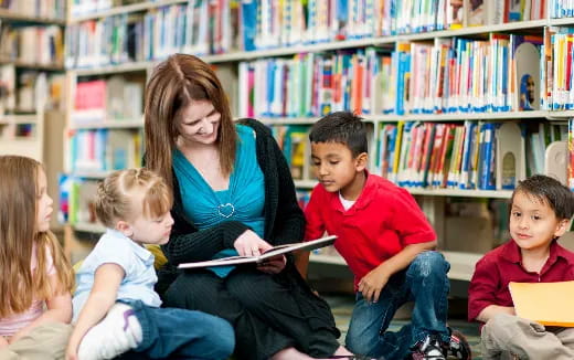a person reading a book to children