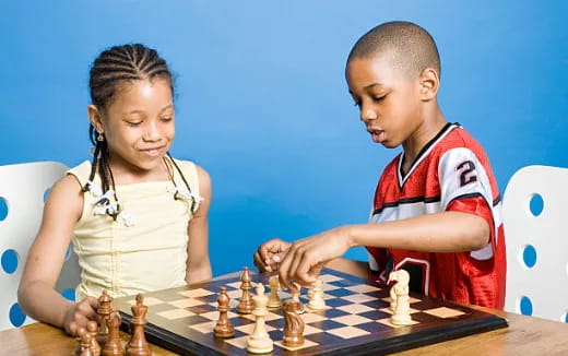 a boy and girl playing chess