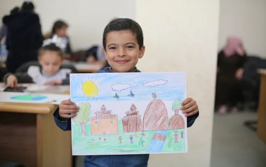 a boy holding a drawing