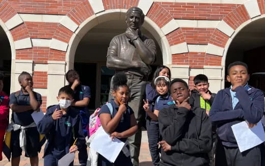 a group of people standing in front of a statue