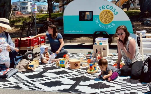 a group of people sitting on the ground with a baby