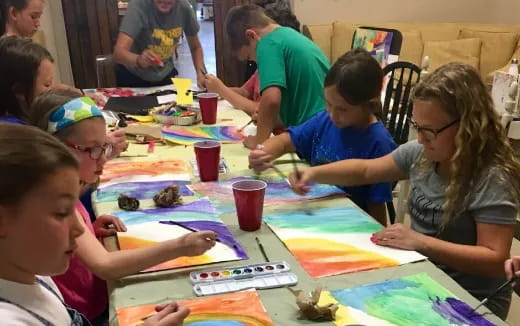 a group of children sitting around a table