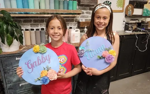 a couple of girls holding a sign