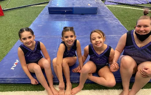 a group of girls in swimsuits sitting on a pool