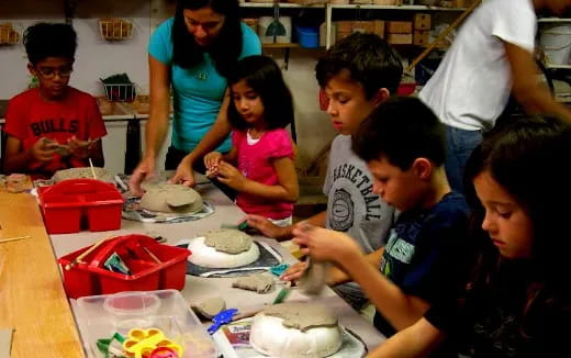 a group of children sitting at a table with food