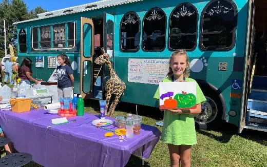 a girl stands in front of a table with a cake