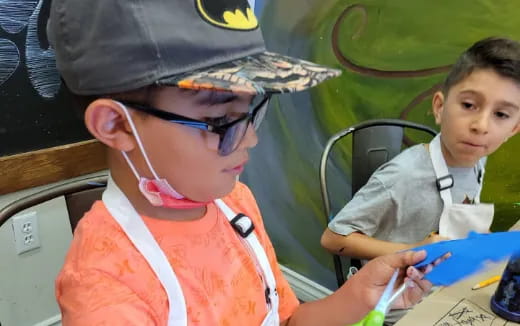 a boy wearing a hat and glasses