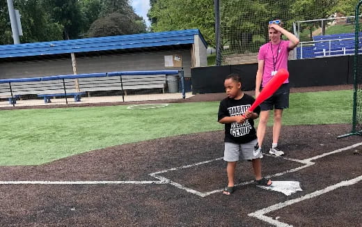 a person and a boy playing baseball