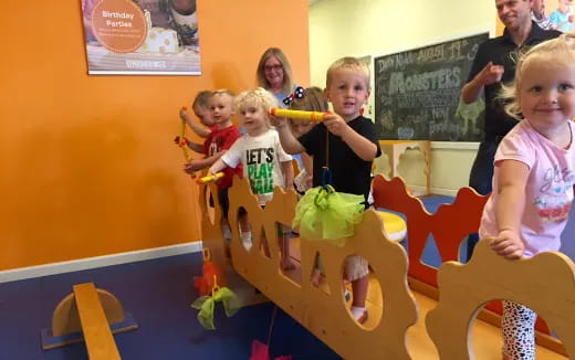 a group of children playing on a toy train