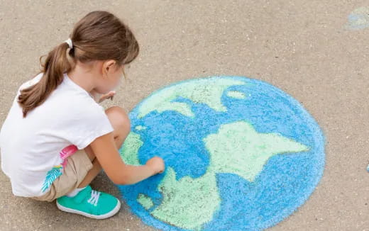 a girl sitting on the ground looking at a blue circle
