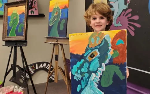 a child holding a painting