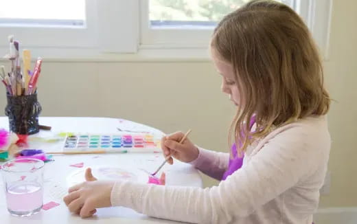 a girl painting on a table