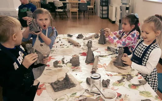 a group of children sitting at a table with toys