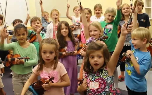 a group of children raising their hands