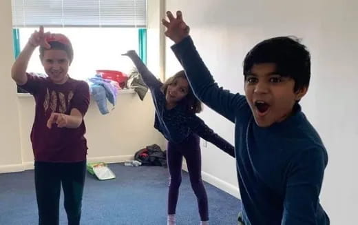 a group of children raising their hands