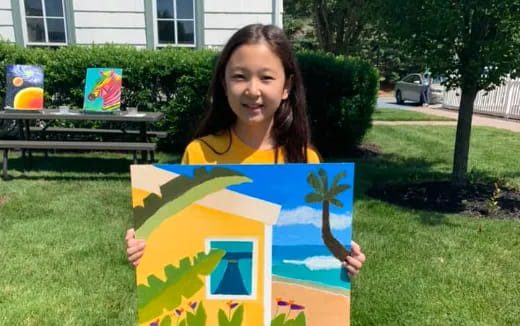 a girl holding a drawing