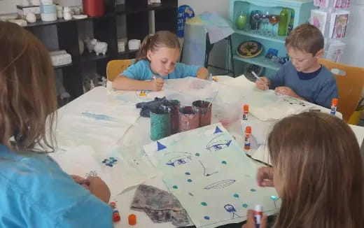 a group of children sitting around a table