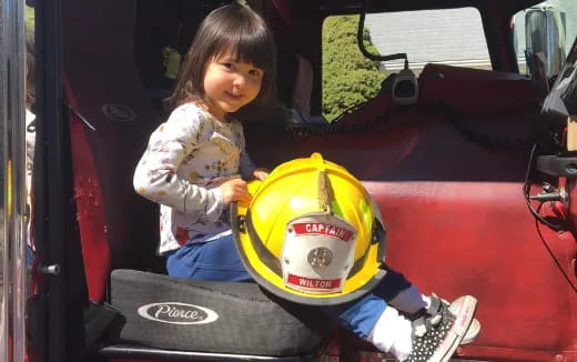 a little girl playing on a toy car