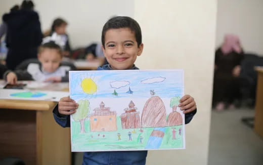 a boy holding a drawing