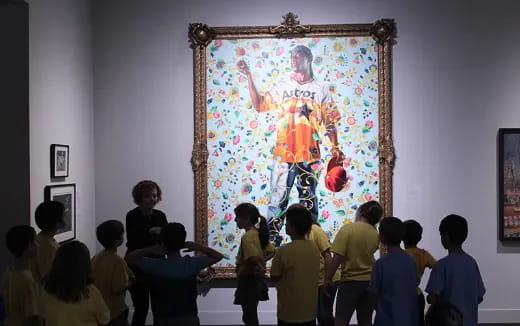 a group of people looking at a painting on a wall