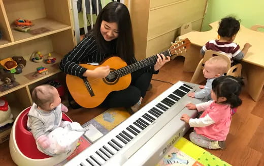 a person playing a guitar with kids