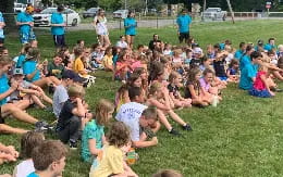 a group of people sitting on the grass