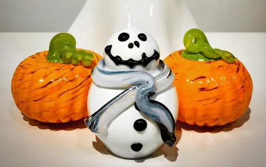 a snowman with a couple of pumpkins