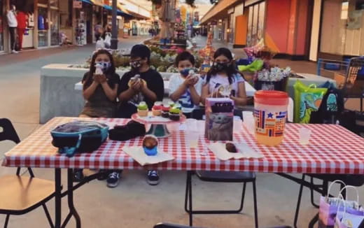 a group of people sitting at a table with food on it