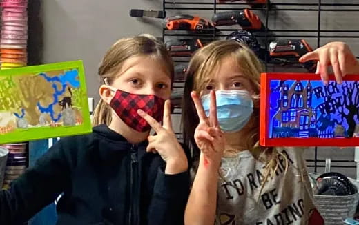 a couple of kids holding up a box with a face mask