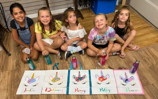 a group of girls sitting on the floor with toys